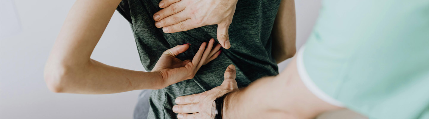 Close-up van een fysiotherapie sessie waarbij de focus ligt op het behandelen van de rug.