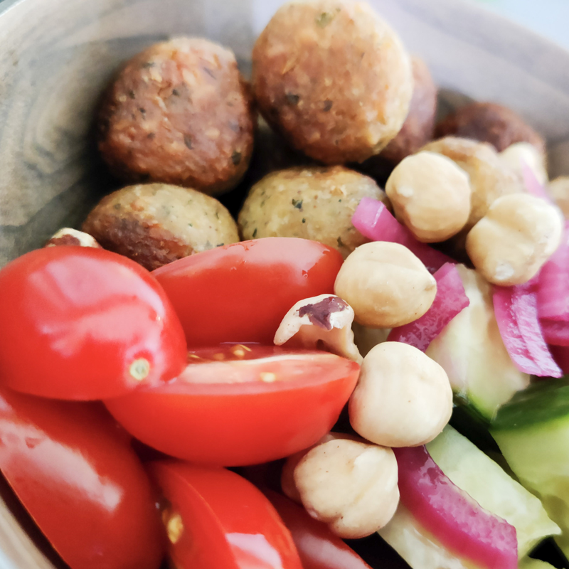 Smakelijke en voedzame maaltijd met gegrilde kip, verse tomaat, knapperige notenkomkommer en een bedje van quinoa, perfect voor sporters die hun spieren willen herstellen en energie willen opdoen.